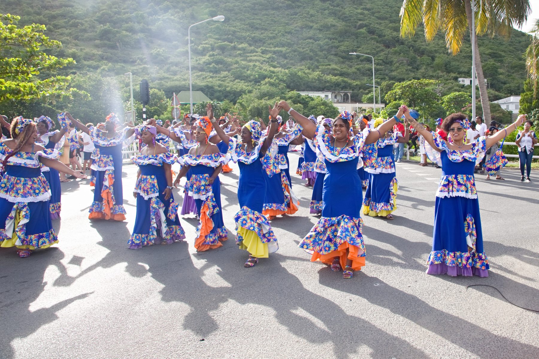 Dancers in traditional dress moving together through the streets of Sint Maarten