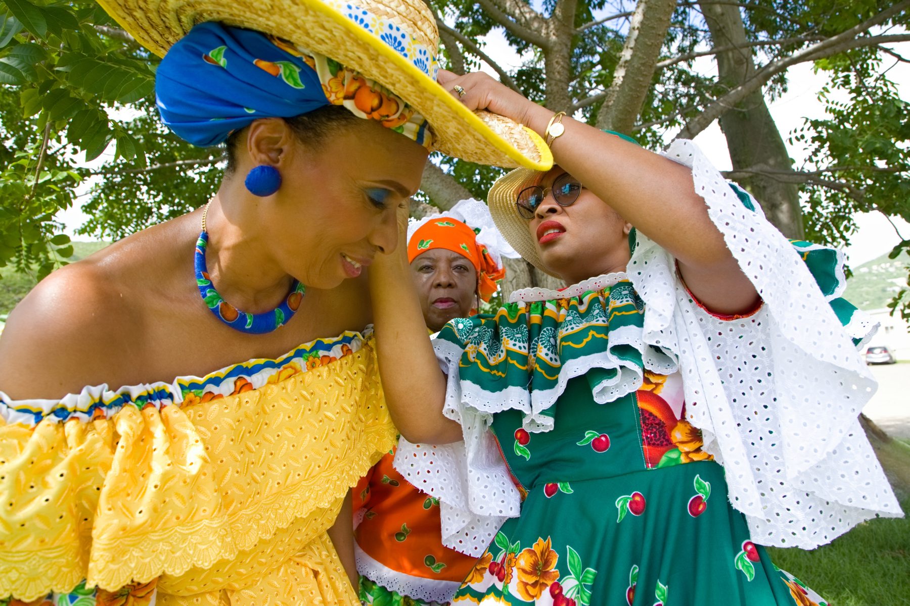 A tradition bearer in Sint Maarten madras dress sharing a moment with a young girl